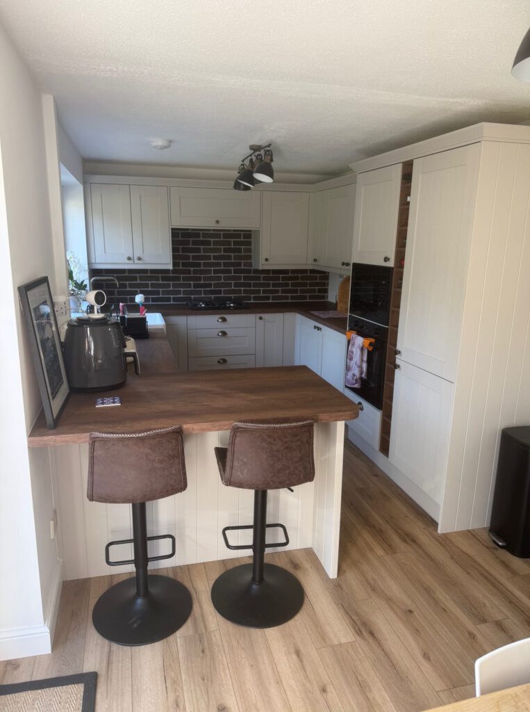 A cream kitchen and wooden worktops that Acorn Installations completed